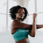 a woman in a sports bra top stretching her arms